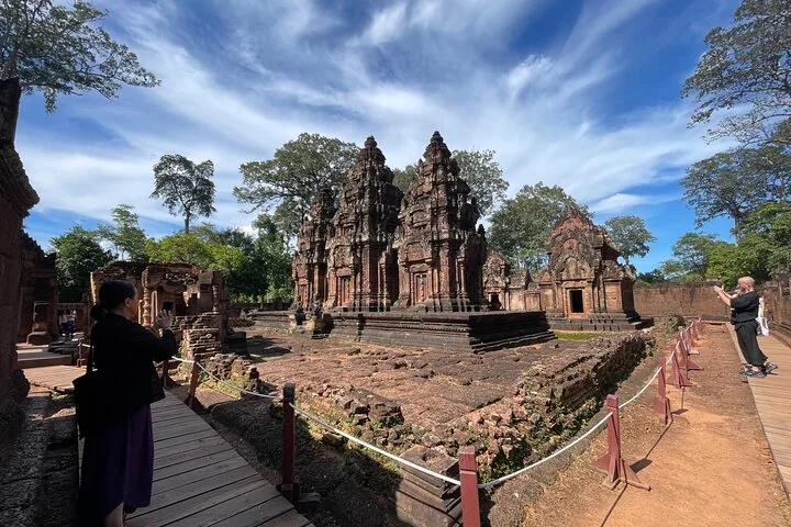 Tourist taking a photo of the main towers at Banteay Srei temple